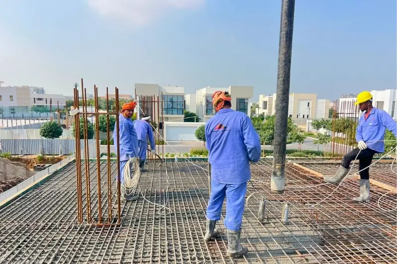 Site team fixing slab reinforcement on a villa roof, Al Zahia Sharjah
