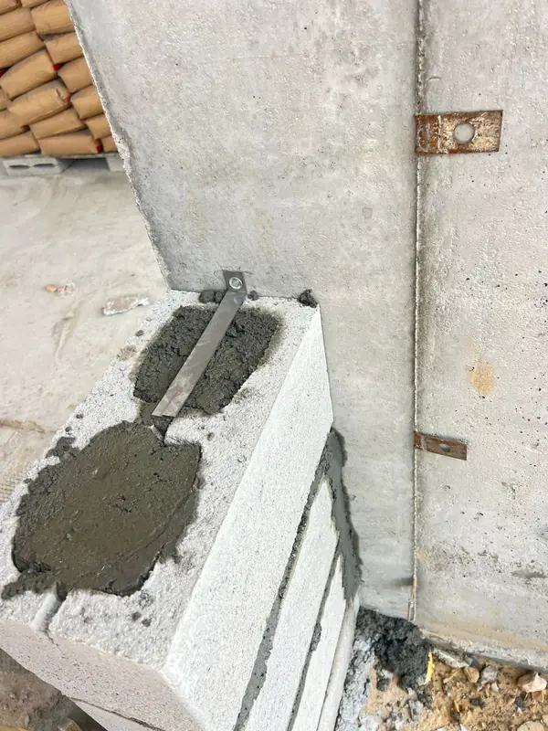 Blockwork laid with mortar beside a reinforced concrete column