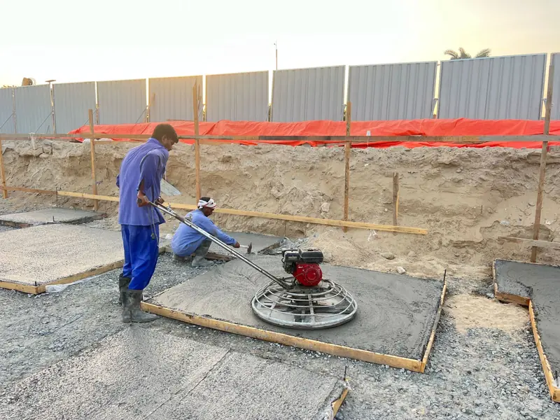 Power trowel finishing a concrete footing base at a villa site, Sharjah